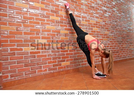 Portrait of young sporty girl doing stretching exercise