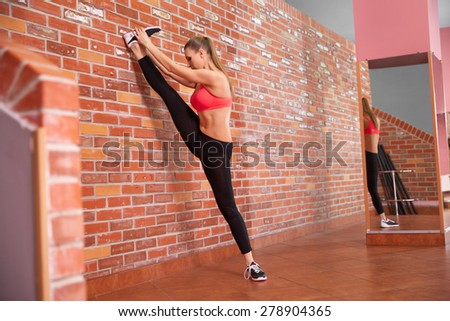Portrait of young sporty girl doing stretching exercise