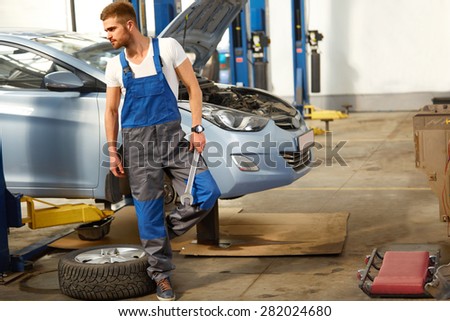 Car Mechanic Changing Tire in Professional Car Repair Service