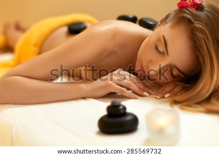 Spa Treatment. Beautiful Blonde Gets Stone Massage.  Wellness Concept