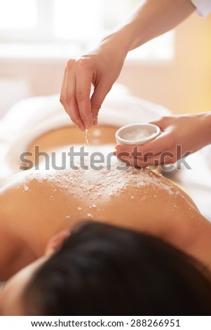 Spa Woman. Brunette Getting a Salt Scrub Beauty Treatment in the Spa. Body Scrub.