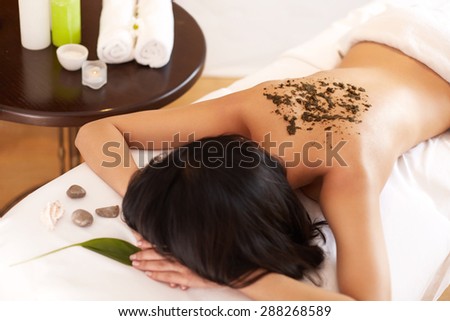 Spa Woman. Brunette Getting a Marine Algae Wrap Treatment in Spa Salon