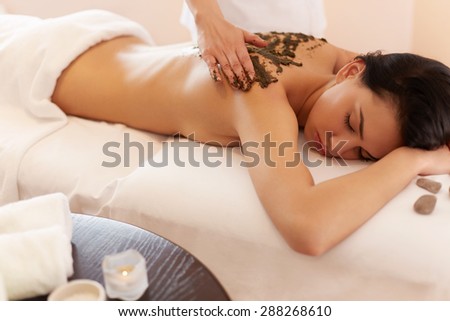 Spa Woman. Brunette Getting a Marine Algae Wrap Treatment in Spa Salon