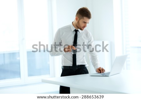 Business Man Works on his Computer at the Office