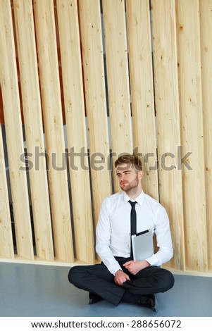 Depressed Businessman sitting on floor at his office. Hard work and stress concept