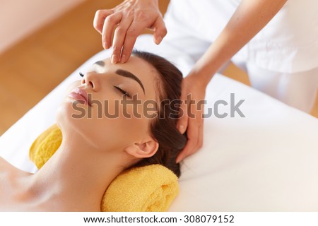 Spa Woman. Beautiful Young Woman Getting a Face Treatment at Beauty Salon. Face Massage