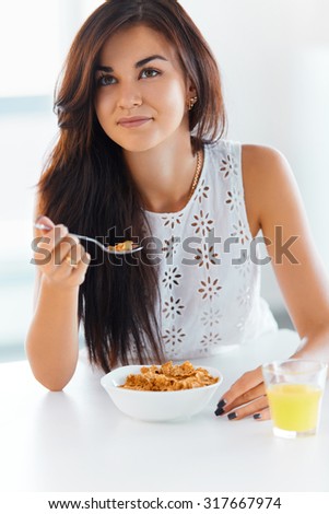 Portrait of beautiful young woman eating cereals. Healthy eating. Health care.