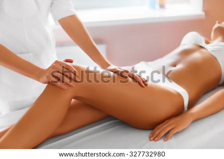 Spa woman. Close-up of sexy woman getting spa treatment. Leg massage therapy in spa salon. Body care, skin care, wellness concept.