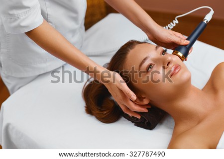 Face skin care.  Woman lies on a table in a medical beauty cosmetology spa salon getting facial skin care treatment. Ultrasound cavitation anti-aging, rejuvenation, lifting procedure. Beauty concept