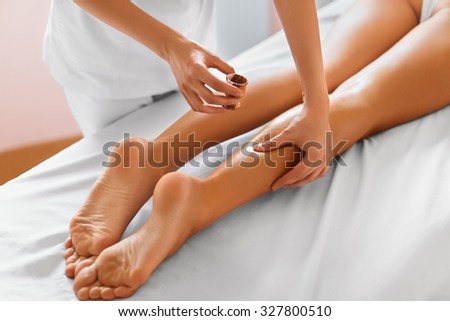 Spa woman. Close-up of sexy woman getting spa treatment. Leg massage therapy in spa salon. Body care, skin care, wellbeing, wellness concept.