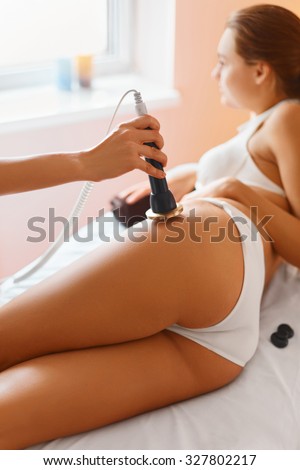 Body care. Ultrasound cavitation body contouring treatment. Woman getting anti-cellulite and anti-fat therapy on her tight buttocks in beauty salon. Spa treatment. Wellness, healthcare, lifestyle.