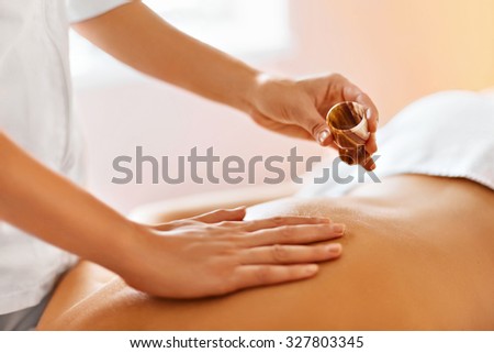 Body massage. Spa therapy. Masseur doing massage on beautiful young healthy caucasian woman body in  spa salon. Beauty treatment concept. Skincare, wellbeing, wellness, lifestyle.