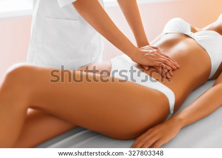 Spa treatment. Body care. Massage on relaxed beautiful young caucasian woman\'s body in the spa salon. Body care, skin care, wellness, wellbeing, beauty treatment concept.