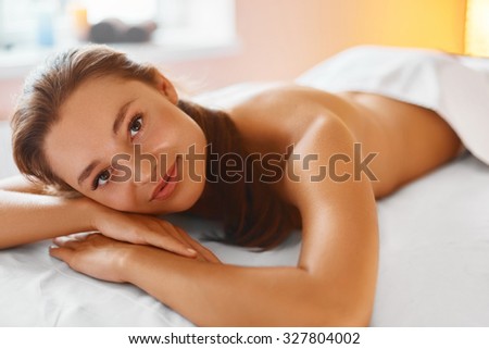 Spa woman. Body care. Massage treatment, skin care, wellness, wellbeing concept. Portrait of relaxed beautiful woman lying on the massage table in medical cosmetology spa salon. Healthy lifestyle