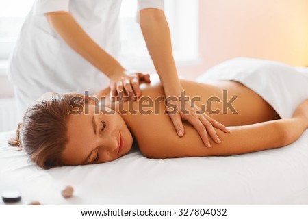 Spa treatment. Woman enjoying relaxing back massage in cosmetology spa centre. Body care, skin care, wellness, wellbeing, beauty treatment concept.