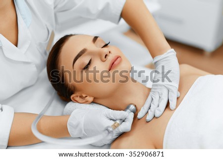 Face Skin Care. Closeup Of Beautiful Woman Getting Diamond Microdermabrasion Peeling Treatment In A Beauty Spa Salon. Cleansing Procedure. Cosmetology.