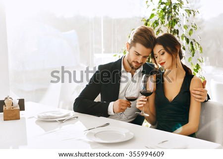 Couple In Love. Happy Romantic Smiling Elegant People Having Dinner, Drinking Wine, Celebrating Holiday, Anniversary Or Valentine\'s Day In Gourmet Restaurant. Romance, Relationships Concept.