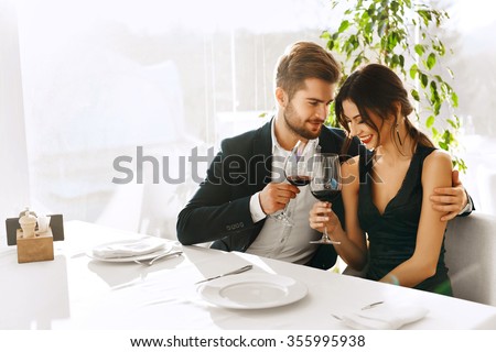 Love. Happy Romantic Smiling Couple Having Dinner, Embracing, Drinking Wine, Celebrating Holiday, Anniversary Or Valentine\'s Day In Gourmet Restaurant. Romance, Relationships Concept. Celebration