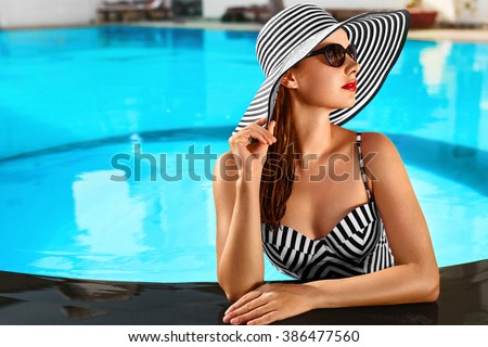 Beautiful Sexy Girl With Healthy Skin In Elegant Striped Bikini, Sun Hat Relaxing In Swimming Pool Water In Resort Spa Hotel On Travel Holidays Vacation.