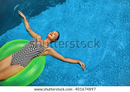 Summer Vacations. Beautiful Sexy Smiling Woman With Perfect Fit Body, Healthy Skin In Swimwear Sunbathing, Floating On Float Swim Ring In Swimming Pool Water. Enjoyment. Beauty, Wellness. Recreation