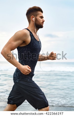 Running Man. Sporty Runner Enjoying Run By Sea During Outdoor Workout. Handsome Fit Athletic Male Jogging On Beach. Healthy Active Jogger Exercising And Training For Marathon. Fitness, Sports Concept