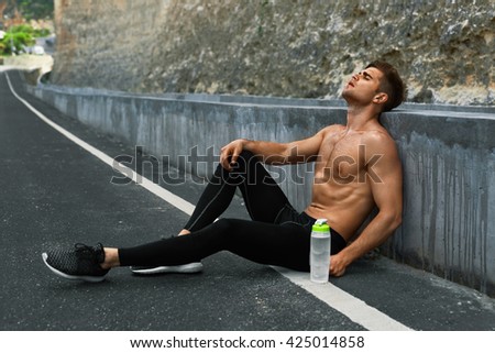 Sports. Tired Exhausted Athletic Man With Fit Muscular Body In Sportswear Resting After Running Outdoors. Topless Handsome Healthy Male Runner Taking Break After Fitness Workout And Exercising.