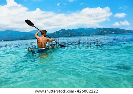 Summer Travel Kayaking. Man Paddling Transparent Canoe Kayak In Tropical Ocean, Enjoying Recreational Sporting Activity. Male Canoeing With Paddle, Exploring Sea On Vacation. Rowing Water Sports