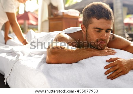 Spa For Man. Beautiful Healthy Happy Male Model Relaxing At Day Spa Beauty Salon. Handsome Guy Enjoying Summer Body Relaxation Treatment, Lying On Relax Massage Table Outdoors. Health Care Concept
