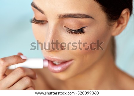 Lips Skin Care Cosmetics. Beautiful Woman With Beauty Face, Sexy Full Lips Applying Lip Balm, Lipcare Stick On. Portrait Of Model Girl With Natural Makeup Putting Hygienic Lipstick On. High Resolution
