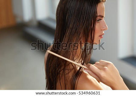 Hair Care. Closeup Of Beautiful Girl After Bath Hairbrushing Healthy Straight Brown Hair. Young Woman Brushing Her Long Wet Hair With Wooden Comb. Health And Beauty Concept. High Resolution Image