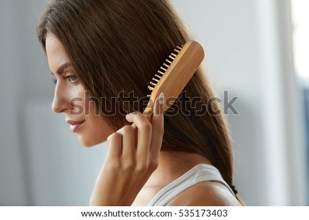 Hair Care. Closeup Of Beautiful Woman Hairbrushing Hair With Brush. Portrait Of Sexy Female Woman Brushing Long Straight Healthy Hair With Hairbrush. Health And Beauty Concept. High Resolution Image