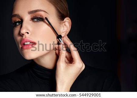 Beauty Cosmetics. Closeup Of Beautiful Sexy Woman Putting Black Mascara On Long Thick Eyelashes With Brush. Fashionable Female Model With Soft Skin, Perfect Makeup And Fake Eyelashes. High Resolution