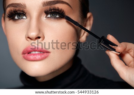 Beauty Make-up. Portrait Of Beautiful Young Woman With Fake Eyelashes Applying Black Mascara On Lashes, Holding Brush In Hand. Sexy Female With Soft Skin And Perfect Makeup. Cosmetics. High Resolution