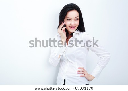 Cheerful business woman conversing on mobile phone