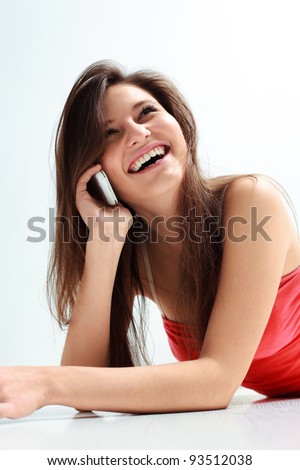 Portrait of a laughing young woman talking on mobile phone