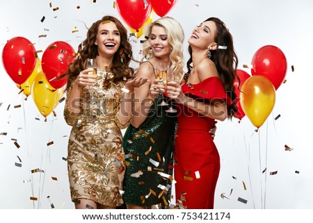 Beautiful Women Celebrating New Year, Having Fun At Party. Portrait Of Happy Smiling Girls In Stylish Glamorous Dresses With Champagne Glasses At Fashion Party. High Resolution.