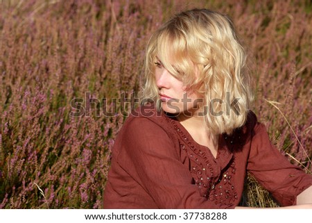 A naturally beautiful young blond woman shot in a field of out of focus heather