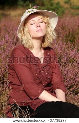A naturally beautiful young blond woman shot in a field of out of focus heather