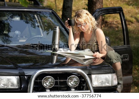 A woman driver reading a road map