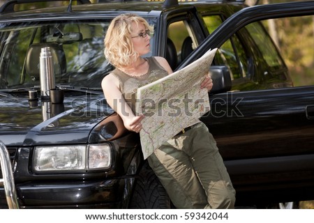 A woman driver reading a road map