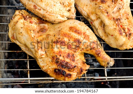 chicken half roasted over a fire