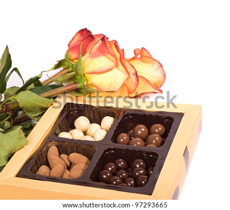 box of chocolates and three roses isolated on a white background