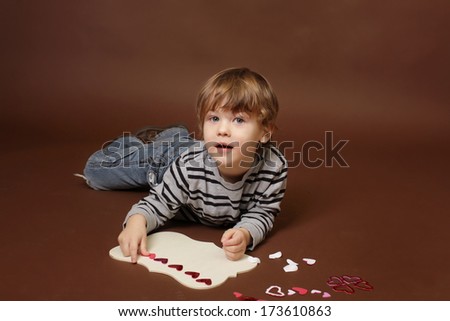 Child making  Valentine's Day Craft with Heart stickers