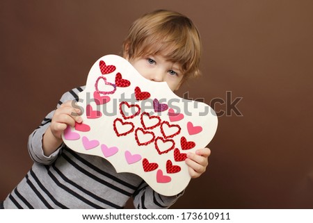 Child holding  Valentine\'s Day Craft with Heart stickers