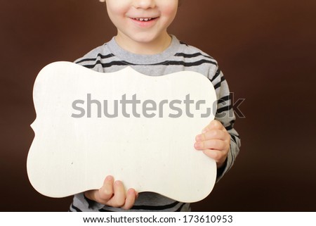 Child holding an empty wood frame, sign