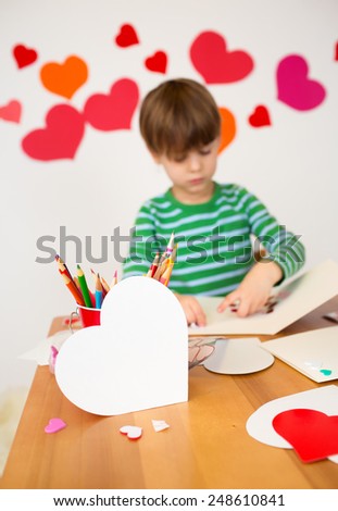 Kids, children, doing Valentine\'s day arts and crafts with hearts, pencils, paper