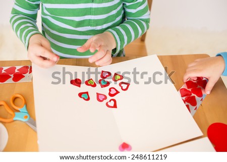 Childs, kids, engaged in a Valentine\'s Day arts and crafts activity