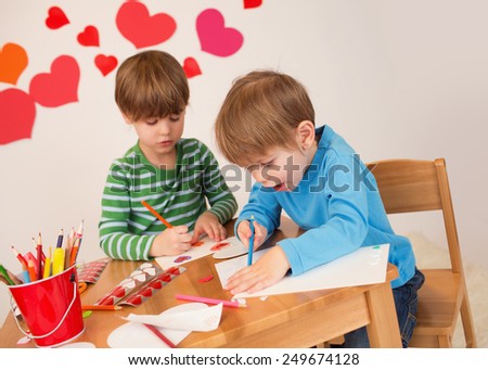 Kids, children, doing Valentine\'s day arts and crafts with hearts, pencils, paper, love concept