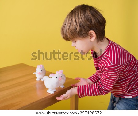 Child having fun and playing with wound up easter bunny toys