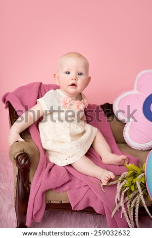 Baby sitting on couch with blanket, baby room and furniture concept